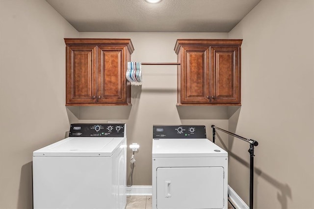 laundry area featuring washer and clothes dryer and cabinets