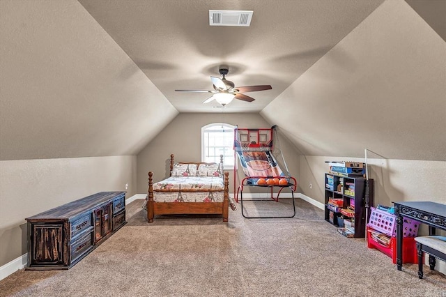 carpeted bedroom featuring a textured ceiling, vaulted ceiling, and ceiling fan