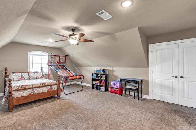 bedroom featuring vaulted ceiling, carpet floors, ceiling fan, and a textured ceiling