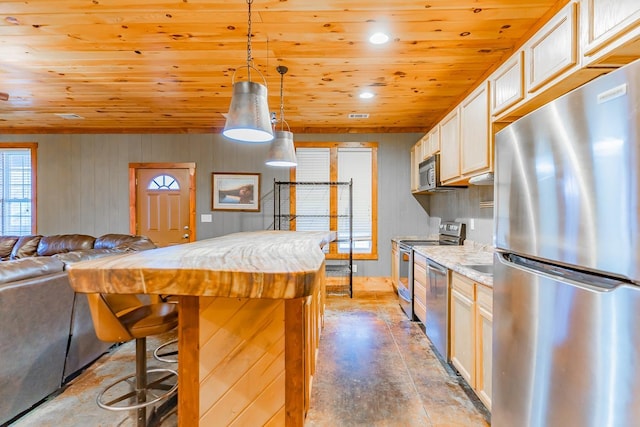 kitchen with appliances with stainless steel finishes, concrete floors, a kitchen breakfast bar, hanging light fixtures, and wooden ceiling