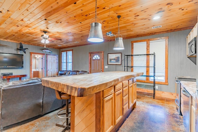 kitchen featuring a kitchen bar, butcher block counters, hanging light fixtures, wooden ceiling, and a kitchen island