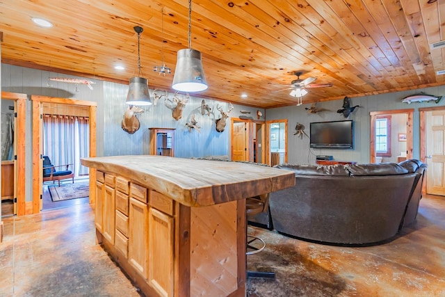 kitchen featuring pendant lighting, a center island, ceiling fan, wood ceiling, and light brown cabinets