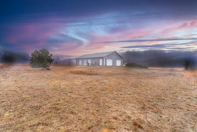 yard at dusk with an outbuilding and a garage