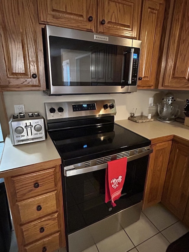 kitchen with light tile patterned floors and appliances with stainless steel finishes