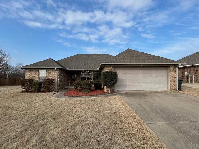 ranch-style home with a garage and a front lawn