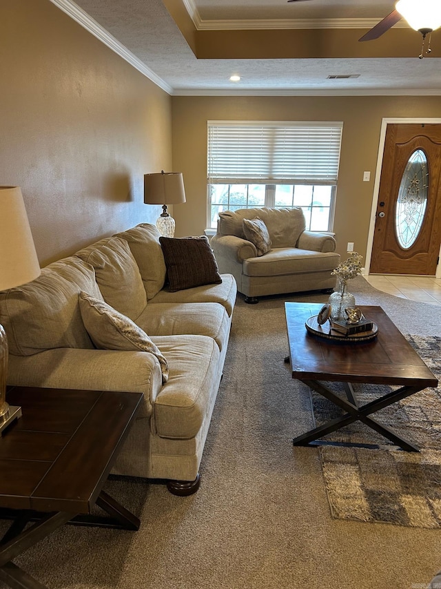 tiled living room with ornamental molding and ceiling fan