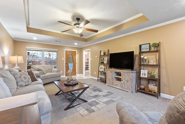 living room with ceiling fan, a tray ceiling, and light carpet