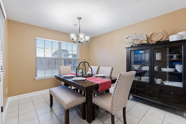 dining room with a notable chandelier, a textured ceiling, and light tile patterned flooring