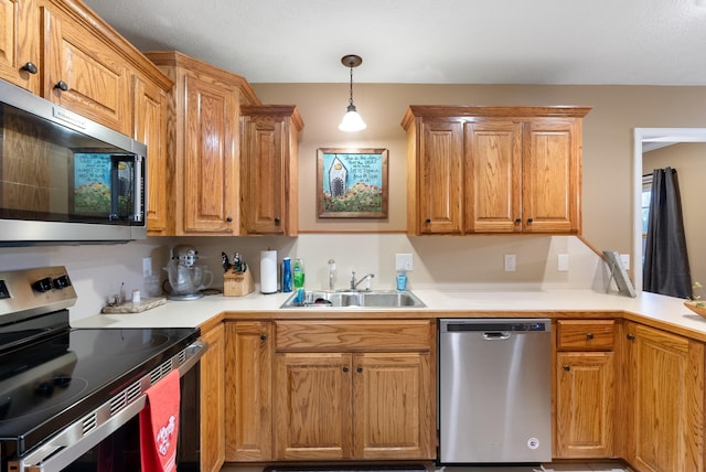 kitchen featuring sink, hanging light fixtures, and appliances with stainless steel finishes