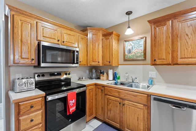 kitchen featuring pendant lighting, sink, light tile patterned floors, and stainless steel appliances