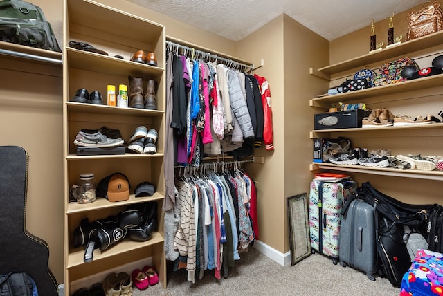 walk in closet featuring light carpet