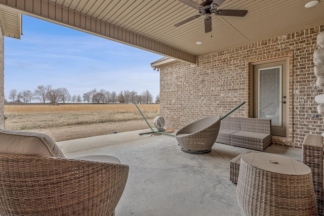 view of patio / terrace with a rural view, an outdoor living space, and ceiling fan