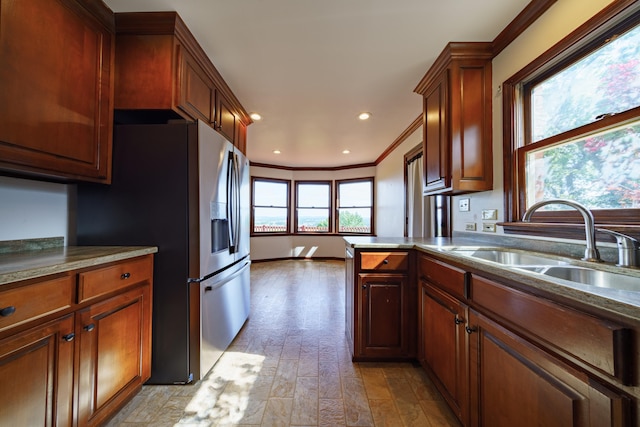 kitchen with crown molding, sink, stainless steel fridge, and light wood-type flooring