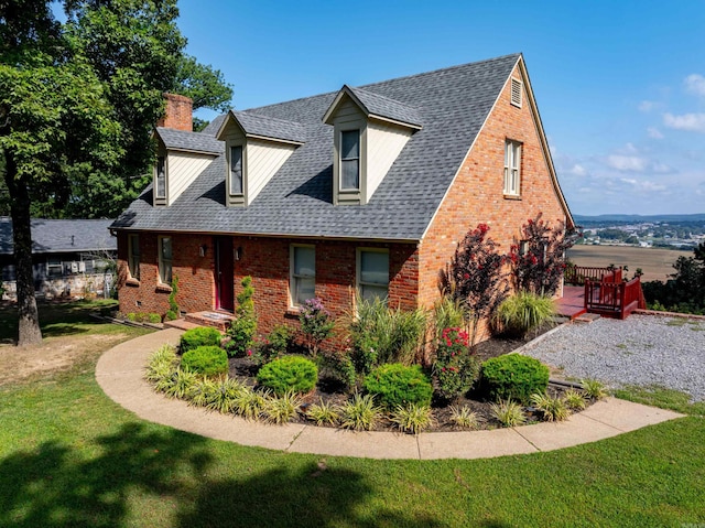 cape cod home featuring a front lawn