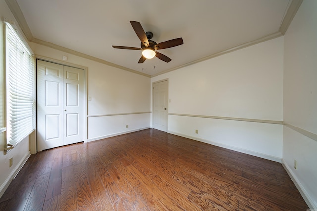 unfurnished bedroom with multiple windows, ornamental molding, ceiling fan, and dark hardwood / wood-style flooring