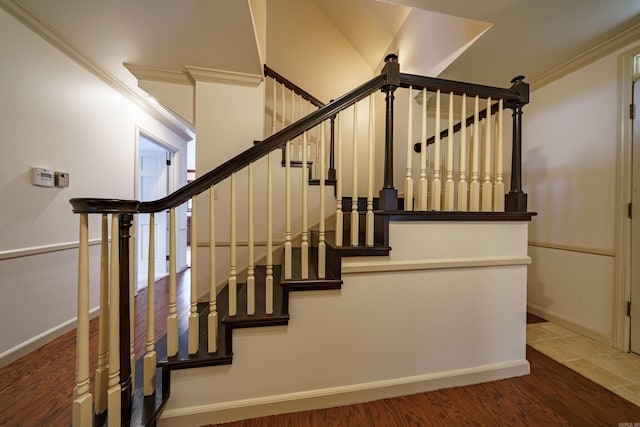 stairs featuring hardwood / wood-style floors and ornamental molding