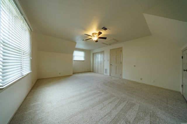 interior space featuring light carpet and vaulted ceiling