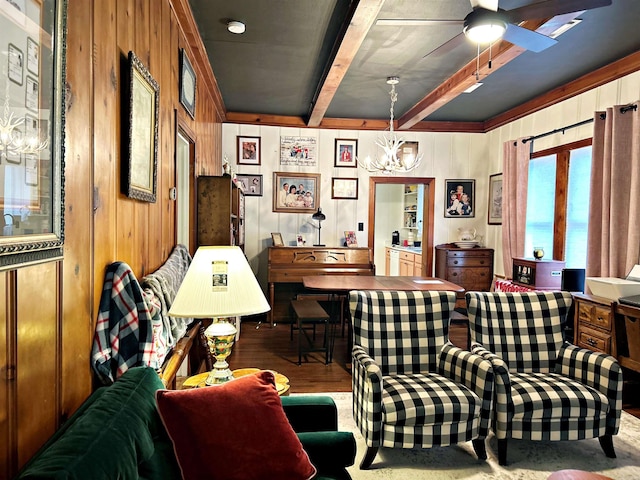 interior space with beamed ceiling, hardwood / wood-style flooring, ceiling fan with notable chandelier, and wooden walls