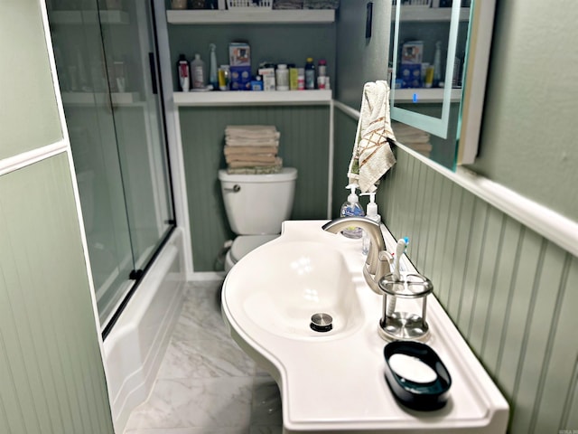 bathroom featuring enclosed tub / shower combo and toilet