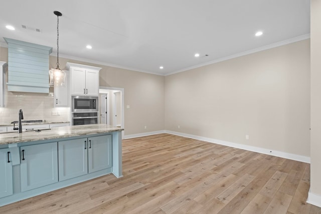 kitchen featuring built in microwave, decorative light fixtures, light stone countertops, oven, and white cabinets