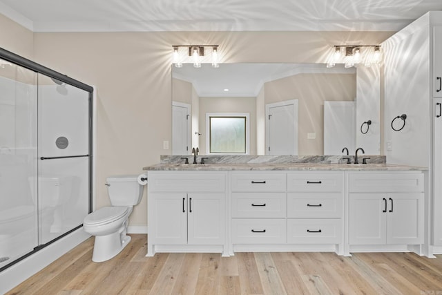 bathroom with hardwood / wood-style flooring, crown molding, and toilet