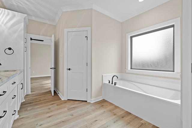 bathroom featuring vanity, a tub to relax in, crown molding, and wood-type flooring