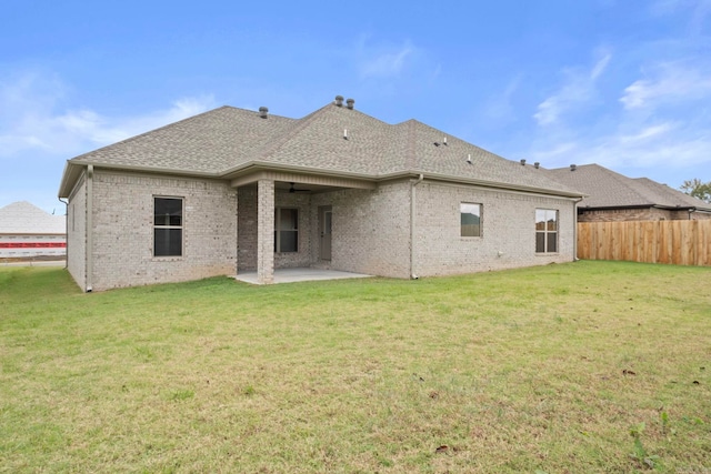 back of house with a yard and a patio