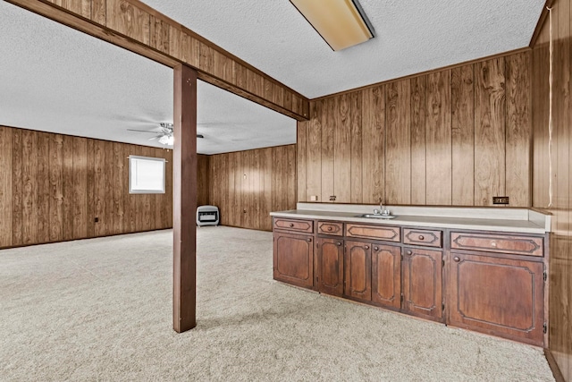 bar featuring ceiling fan, wood walls, light carpet, and a textured ceiling