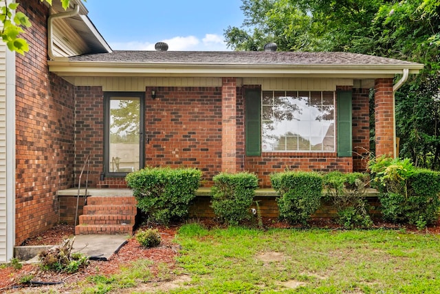 view of exterior entry with a lawn