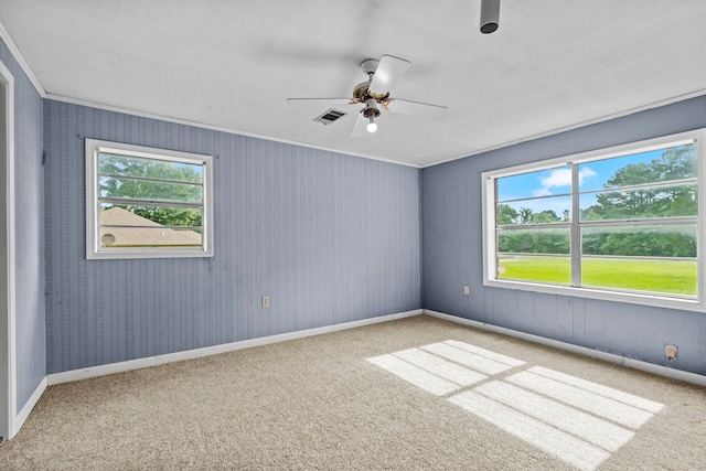 spare room with crown molding, carpet flooring, and ceiling fan