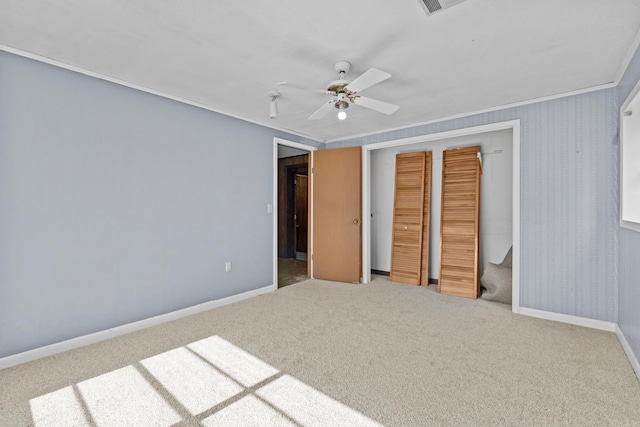 unfurnished bedroom with ornamental molding, carpet, ceiling fan, and a closet