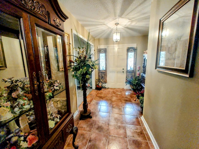 entrance foyer featuring light tile patterned floors and a textured ceiling