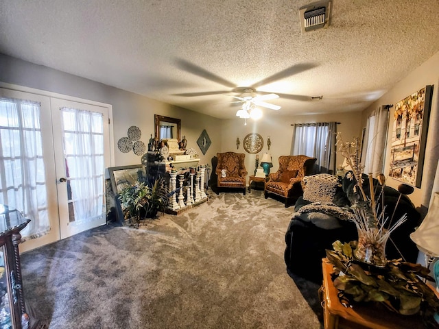 carpeted living room with french doors, ceiling fan, and a textured ceiling
