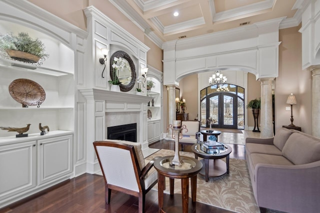 living room featuring built in features, decorative columns, coffered ceiling, crown molding, and french doors