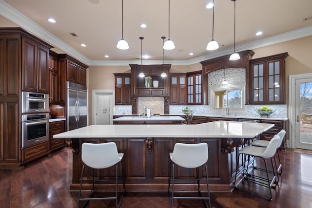 kitchen with a large island, hanging light fixtures, and appliances with stainless steel finishes