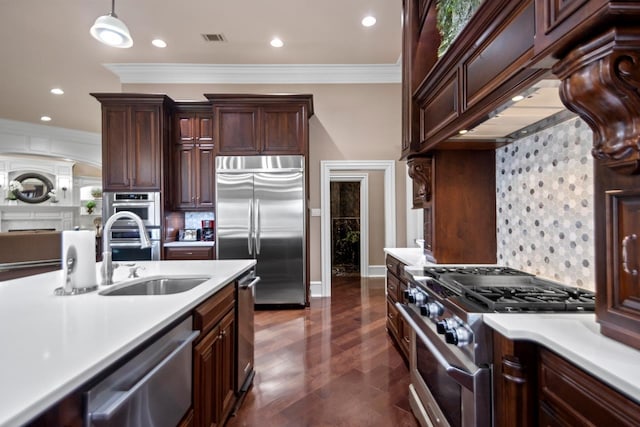 kitchen featuring decorative light fixtures, high quality appliances, sink, custom exhaust hood, and dark brown cabinets