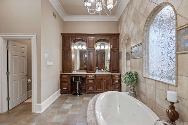 bathroom featuring tiled tub, tile walls, ornamental molding, vanity, and a notable chandelier