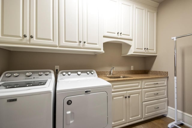 washroom with dark hardwood / wood-style flooring, sink, cabinets, and washing machine and clothes dryer