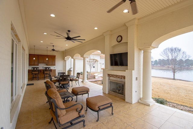 view of patio featuring a tile fireplace and ceiling fan