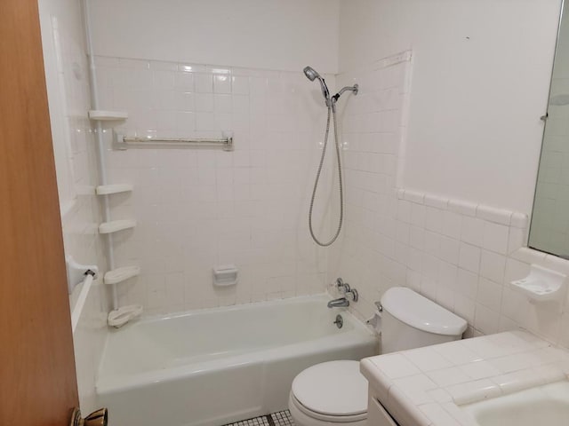 full bathroom featuring tile walls, vanity, toilet, and tiled shower / bath