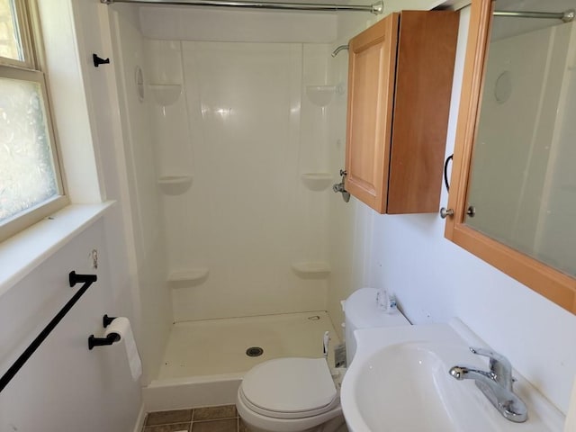 bathroom with tile patterned flooring, toilet, sink, and walk in shower