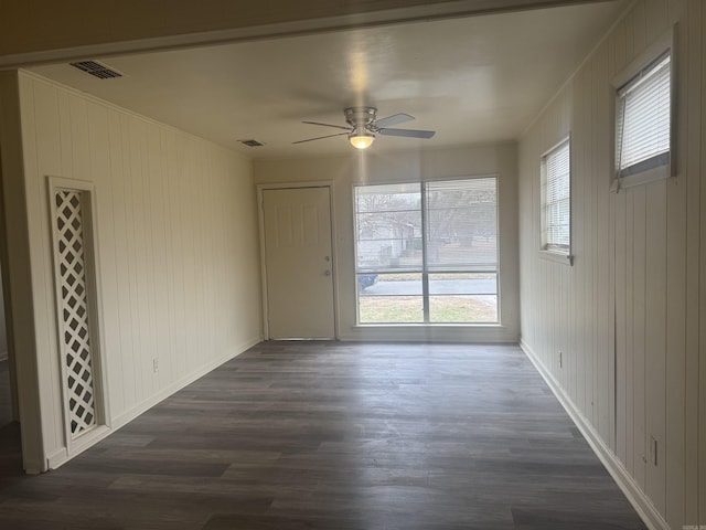 unfurnished room featuring dark hardwood / wood-style flooring, crown molding, and ceiling fan