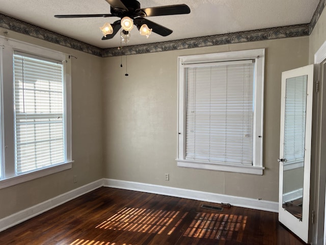 spare room with ceiling fan, dark wood-type flooring, and a textured ceiling