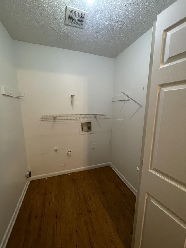 washroom with washer hookup, a textured ceiling, dark hardwood / wood-style flooring, hookup for a gas dryer, and hookup for an electric dryer