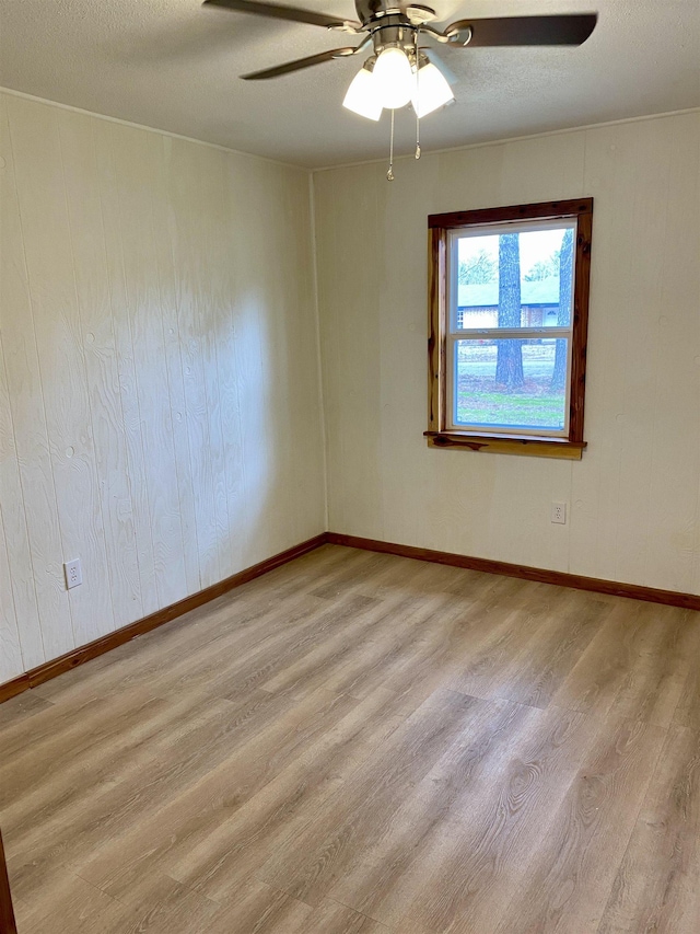 spare room featuring ceiling fan, light hardwood / wood-style flooring, and a textured ceiling