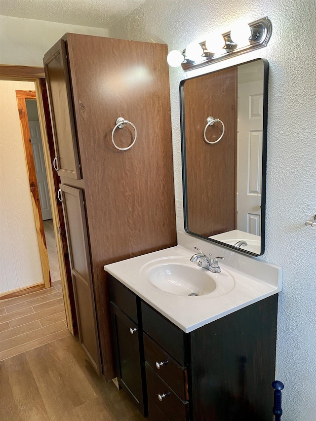 bathroom with vanity, hardwood / wood-style flooring, and a textured ceiling