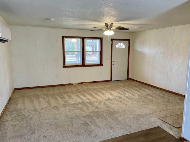 interior space featuring ceiling fan, carpet floors, a textured ceiling, an AC wall unit, and wood walls