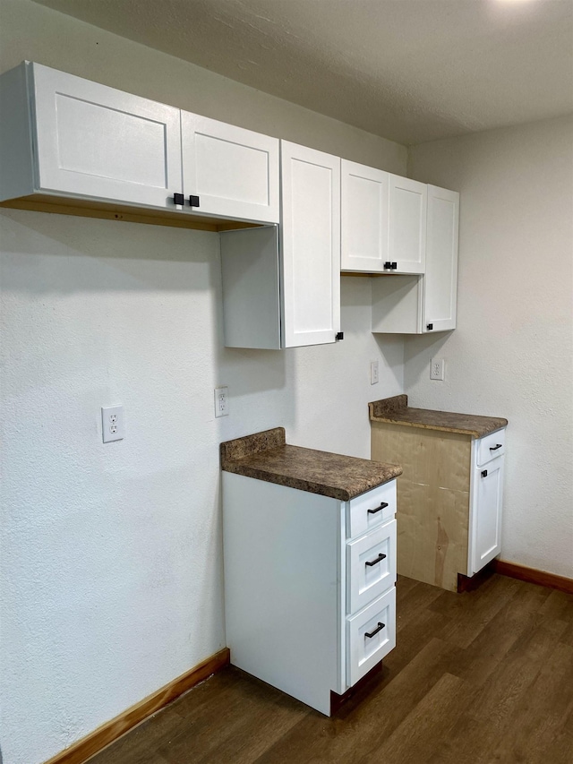 kitchen with dark wood-type flooring and white cabinets