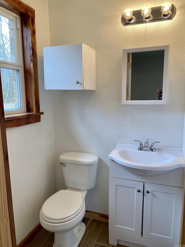 bathroom with hardwood / wood-style flooring, vanity, and toilet