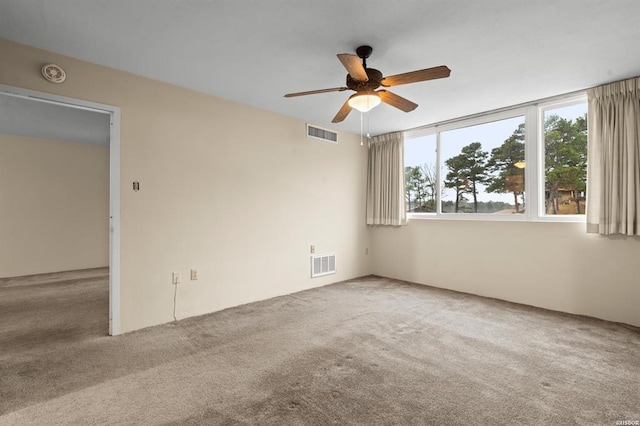 carpeted spare room with ceiling fan